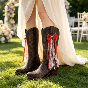 Detailed view of brown western cowboy boots decorated with red bow and pearl lace streamers.