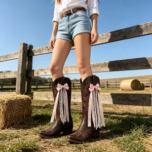 Western cowboy boots in dark brown featuring elegant pink bow, lace, and pearl tassel details.