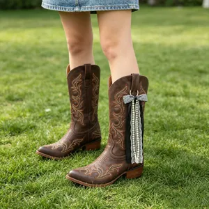 Vue détaillée de botte de cowboy western marron avec nœud noir chic et gland de perles.