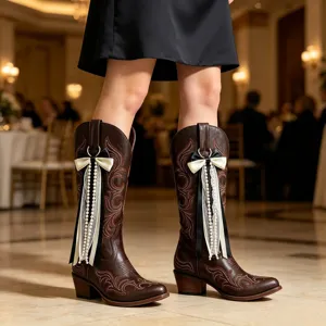 Braune Western-Cowboy-Stiefel mit filigraner Stickerei, schicken Schleifen und Perlen.