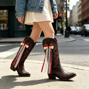 Detaillierte braune Western-Cowboy-Stiefel mit schicken Schleifen und eleganten Perlenquasten.