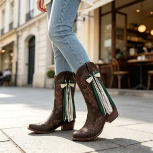 Detailaufnahme brauner Westernstiefel mit schicker Perlen-Schleife und Stickerei.