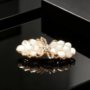 Elegant gold-tone hairpin with white cat's eye stone and sparkly rhinestones.