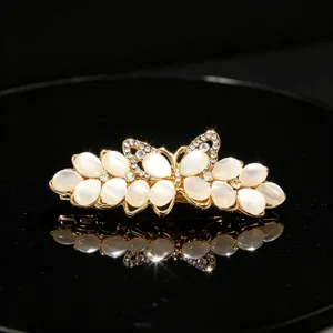 Elegant rhinestone and cat's-eye stone hair clip with exquisite flower and bow details.