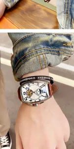 Detailed shot of tonneau automatic mechanical watch with white dial, Arabic numerals, leather strap.