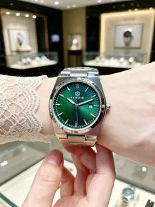 Close-up shot of men's green dial quartz watch with stainless steel strap on wrist.