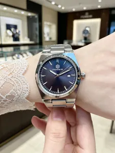 Detail view of the elegant blue dial men's steel watch worn on wrist with clear markers.