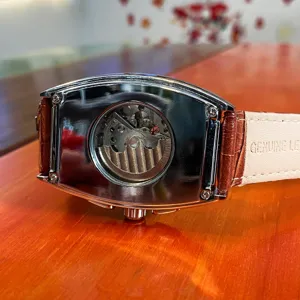 Men's tonneau automatic mechanical watch with skeleton dial and brown leather strap.
