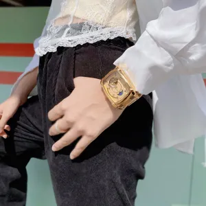 Goldene quadratische automatische Herrenarmbanduhr mit Skelettzifferblatt und Metallband.