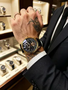 Luxurious men's automatic mechanical watch with gold case, black dial and leather strap.