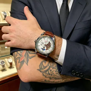 Men automatic mechanical watch detail, white dial, brown leather strap, stylish wristwear.