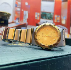 Nahaufnahme Detail der Herren Quarzuhr mit goldenem Zifferblatt und edlem Armband.