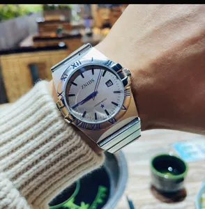 Nahaufnahme der Quarzuhr am Handgelenk mit silbernem Zifferblatt und Metallarmband.
