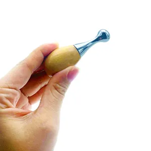 Stainless steel facial gua sha tool with wooden handle for eye and facial massage.