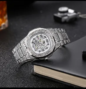 Close-up of vintage engraved mechanical skeleton watch showing intricate steel relief craftsmanship.