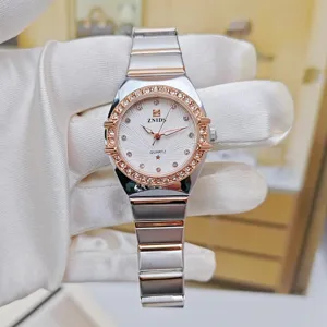 Elegant women's quartz wristwatch featuring a diamond-studded bezel and two-tone metal strap.
