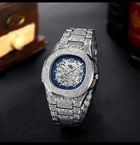 Detailed view of engraved mechanical watch featuring a blue skeleton dial and steel strap.