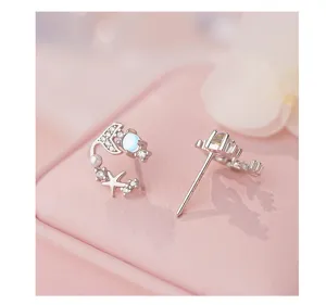 Delicati orecchini in argento con coda di balena, pietra di luna e zirconi brillanti.