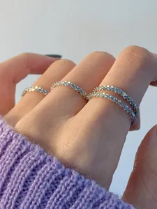 Nahaufnahme von stapelbaren glitzernden silbernen schmalen Ringen, elegantes Design.