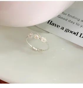 Gros plan détaillé de la bague fleur de perle triple douce en argent S925, bijoux délicats ajustables.