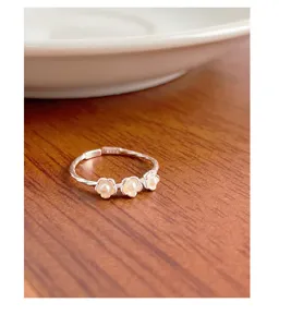 Gros plan sur les détails de la bague ouverte perle à trois fleurs en argent S925.