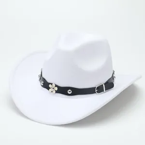 White wool cowboy hat detail, showing the black studded strap and flower charm with buckle.