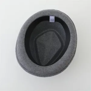 Close-up detail view of the grey wool felt fedora hat interior lining and woven label.