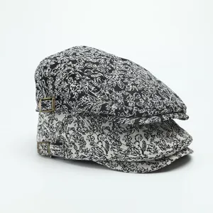 Close-up detail of retro jacquard ivy flat cap with adjustable metal buckle, black and white.