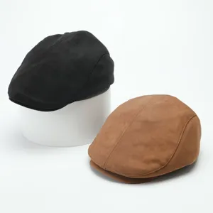 Close-up detail shot of vintage suede flat caps in black and brown colors, stylish hat view.