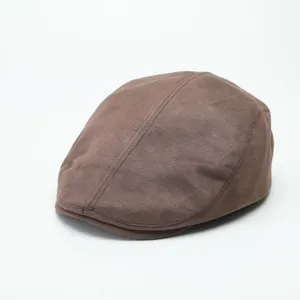 Close up view of brown suede flat cap detail, showcasing vintage style and soft texture fabric.