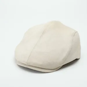 Detailed close-up view of beige suede flat cap, showing fine texture and neat stitching.