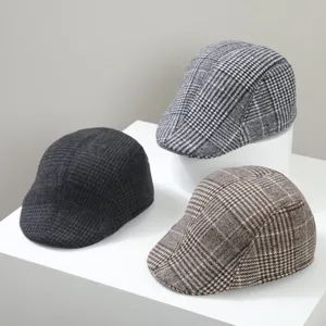 Vue détaillée de casquettes plates classiques à carreaux avec textures élégantes.