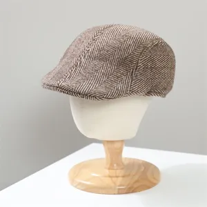 Close-up of a brown herringbone tweed flat cap, retro ivy newsboy hat detail view.