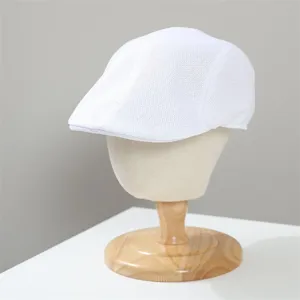Dettaglio di coppola bianca in rete traspirante, cappello leggero con trama e vestibilità cura.