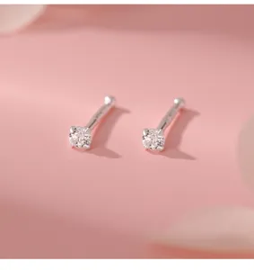 Detailweergave van zilveren zirkoon oorbellen, delicate kleine sieraden voor oren.
