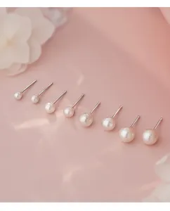 Nahaufnahme von eleganten Perlen-Ohrsteckern in verschiedenen Größen mit Silber.