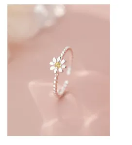 Delicate silver daisy flower beaded open ring, minimalist floral jewelry detail shot.