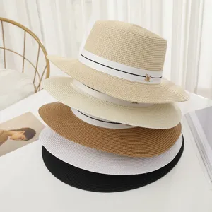Gros plan de chapeaux de paille empilés multicolores sur table blanche, belle vue détail.