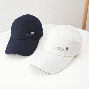 Detail view of casual cotton baseball caps in dark blue and white with printed logo.
