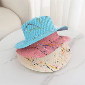 Detail view of colorful graffiti straw sun hats stacked together with fine woven straw texture.