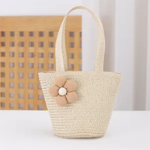 Woven straw handbag with cute fabric flower detail, perfect beach vacation accessory for women.