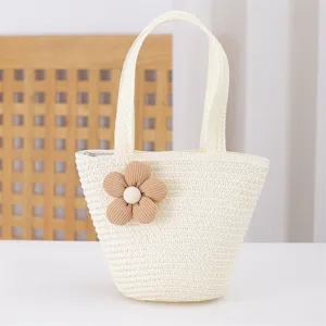 Close up of the woven straw texture and cute fabric flower detail on the mini handbag.