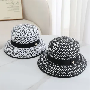 Vue détaillée de chapeaux de paille noirs et blancs élégants pour une protection solaire chic.