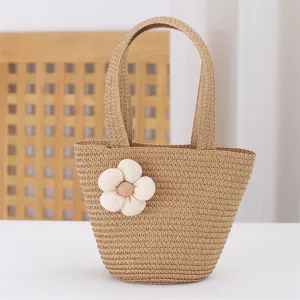 Detailed view of the cute straw woven handbag featuring a white fabric flower, perfect for beach.