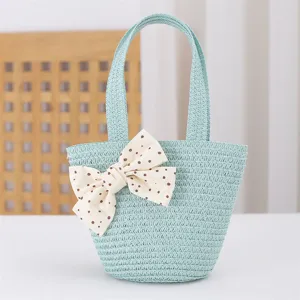 Primer plano detalle del bonito bolso de paja de verano para niños con lazo de lunares.