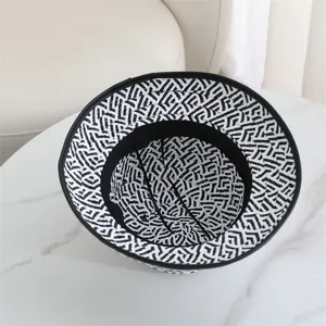 Gros plan sur la texture et les bords du chapeau bob à motif géométrique noir.