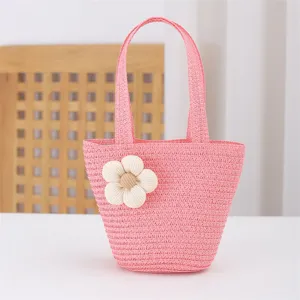 Cute pink straw woven mini tote bag detail featuring a white fabric flower for summer beach.