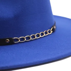 Detailaufnahme blauer Wollfilz Hut, elegante Goldkette mit schwarzem Lederriemen.