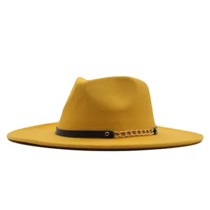 Klassischer gelber Fedora-Hut mit schwarzem Leder- und Goldkettenriemen fuer den Herbst.