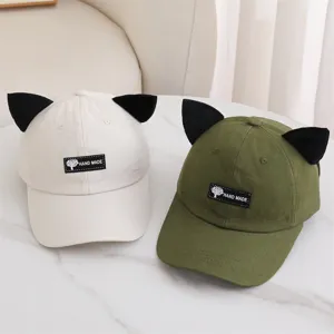 Vista detallada de gorras de béisbol con orejas de gato en beige y verde. Estilo casual.